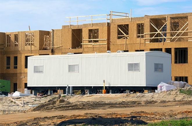 workers studying blueprints in a temporary rental office in Bryan, TX